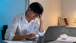 © snowing12 - Overwork Concept The male officer resting his forehead on his right hand while working late at his desk