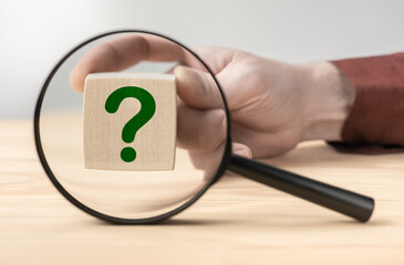 Fototapete - Man hand holding question mark in front of magnifying glass. Search for an answer to question. Research, searching or investigating something. search for solution to problem