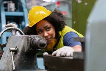 Concept of technician heavy industry, Woman African American engineer wear hardhat working at machine in factory. Female technician control metalwork lathe industrial.