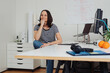 Leinwandbild Motiv Portrait of a confident woman sitting at her desk in the office