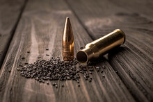 Macro Shot Of A Cartridge, Cartridge Case And Gunpowder On A Wooden Background, Soft Focus.
