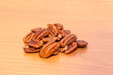 Wall Mural - Pecan nut halves on wooden table.