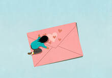 Woman Kneeling Over Pink Envelope With Hearts
