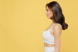 © ViDi Studio - Side profile view young brunette caucasian beautiful skinny woman 20s wear white brassiere underwear isolated on plain yellow color background studio portrait. Plastic surgery breast bodycare concept.
