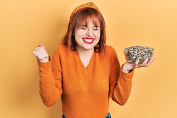 Poster - Redhead young woman holding sunflower seeds bowl screaming proud, celebrating victory and success very excited with raised arm