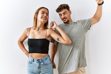 Wall Mural - Young beautiful couple standing together over isolated background stretching back, tired and relaxed, sleepy and yawning for early morning