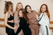 © Кирилл Горшков - multiracial group of girls standing against the wall, sporty happy women laughing, talking while relaxing after a sports workout