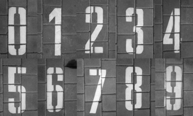 Numbers from zero to nine on pavement in black and white.