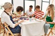© Krakenimages.com - Group of people smiling happy drawing sitting on the table at art studio.