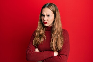 Canvas Print - Young blonde woman wearing turtleneck sweater skeptic and nervous, disapproving expression on face with crossed arms. negative person.