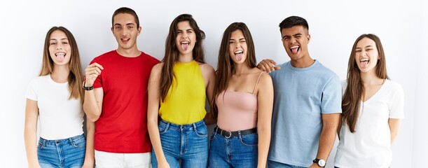 Wall Mural - Group of people wearing casual clothes standing over isolated background sticking tongue out happy with funny expression. emotion concept.