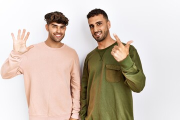 Poster - Young gay couple standing over isolated white background showing and pointing up with fingers number seven while smiling confident and happy.