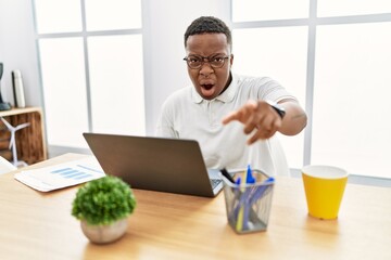 Poster - Young african man working at the office using computer laptop pointing displeased and frustrated to the camera, angry and furious with you