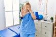 © Krakenimages.com - Beautiful blonde physiotherapist woman working at pain recovery clinic covering eyes with hands and doing stop gesture with sad and fear expression. embarrassed and negative concept.