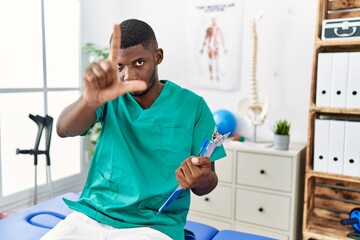 Sticker - Young african american man working at pain recovery clinic pointing with finger up and angry expression, showing no gesture