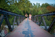 © luisrojasstock - young female couple running in sportswear on a bridge