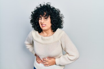 Poster - Young middle east woman wearing casual white tshirt with hand on stomach because nausea, painful disease feeling unwell. ache concept.