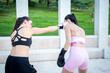 © luisrojasstock - young girl punching her friend in the face with boxing gloves