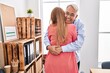 © Krakenimages.com - Middle age man and woman business workers hugging each other at office