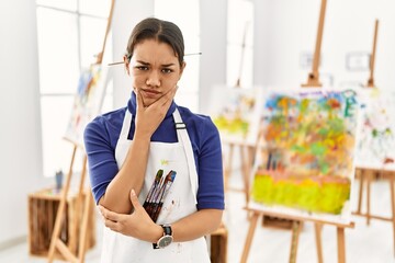 Sticker - Young brunette woman at art studio thinking looking tired and bored with depression problems with crossed arms.