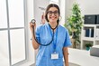 © Krakenimages.com - Young hispanic doctor woman wearing stethoscope at the clinic looking positive and happy standing and smiling with a confident smile showing teeth