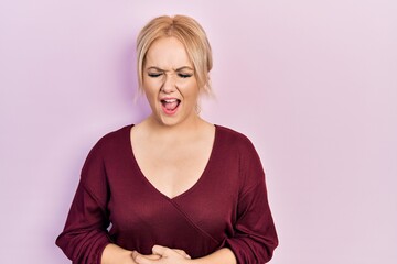 Canvas Print - Young blonde woman wearing casual winter sweater with hand on stomach because nausea, painful disease feeling unwell. ache concept.