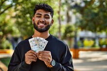 Young Arab Man Smiling Confident Holding Sol Peruvian Banknotes At Park
