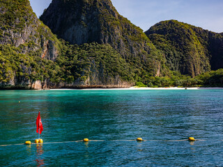 Red forbidding flag and View of Maya Bay, closed for tourism by authorities aimed at reversing the environmental damage caused by excessive tourism on the island.