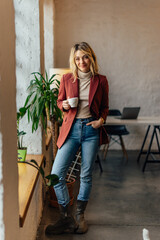 Wall Mural - Portrait of beautiful blonde woman, looking at the camera, drinking coffee.