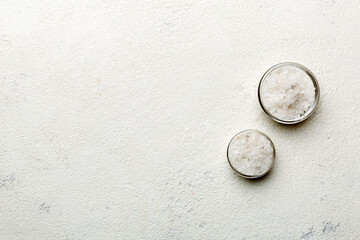 a wooden bowl of salt crystals on a wooden background. salt in rustic bowls, top view with copy spac