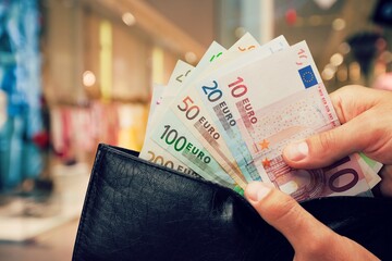 Canvas Print - Hand taking out money from pocket wallet. Counting money, economy concept, money distribution