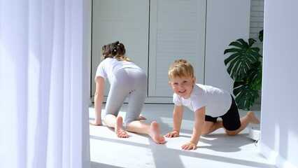 brother and sister play catch-up on the floor. a small baby crawls on the floor, and the girl catche