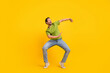 Full length photo of young cheerful man dance have fun clubber look empty space isolated over yellow color background