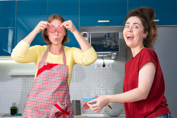 Portrait of two young caucasian women cook in the kitchen and have fun together. Indoors. Concept of joint home cooking for LGBT couples