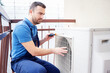 Technician installing air conditioner condenser outdoor for hvac service