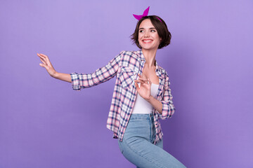 Poster - Profile side photo of young cheerful pretty girl have fun dance look empty space isolated over purple color background