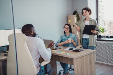 Wall Mural - Photo of cheerful happy agents sitting table working discussing last news smiling indoors workplace workstation