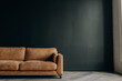 © Igor - Brown sofa on a dark gray wall background. Conceptual photo of an interior with a place for an inscription