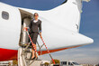 © Kostiantyn - Woman flight attendant standing on aircraft boarding stairs