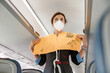 © Kostiantyn - Flight attendant demonstrating how to use life vest in airplane