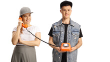 Young Man Holding A Vintage Rotary Phone And A Young Female Talking