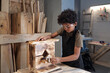 © pressmaster - Portrait of teenage African-American boy building wooden birdhouse in carpentry workshop, copy space