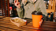 © brillianata - Woman eating tasty french fries and drinking tea or coffee in outdoor cafe. Woman at an urban outside street food court. Close-up photo