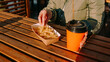 © brillianata - Woman eating tasty french fries and drinking tea or coffee in outdoor cafe. Woman at an urban outside street food court. Close-up photo