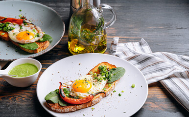 Poster - delicious and appetizing bruschetta with fried eggs and herbs for breakfast