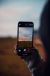 © Goran - Taking a photo of sunset with phone in hand