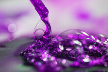 Close-up Of Abstract, Purple Water Splash, Drops On A Blurred Background