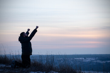 Wall Mural - Prayer. A man on his knees. With your hands up. Glorification of God. Glory to God.