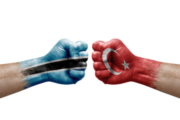 Two hands punch to each others on white background. Country flags painted fists, conflict crisis concept between botswana and turkey