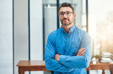 Canvas Print - Setting the bar as a leader. Portrait of a mature businessman standing in an office.